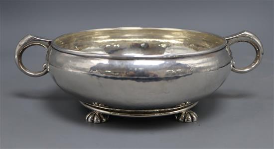 A George V planished silver two handle shallow fruit bowl, on four lobed feet, Goldsmiths & Silversmiths, London, 1928,